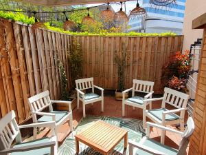 d'une terrasse avec des chaises, une table et une clôture. dans l'établissement T3 - PARIS 10' Confort & Modern - Terrasse - Parking - WIFI, à Gentilly