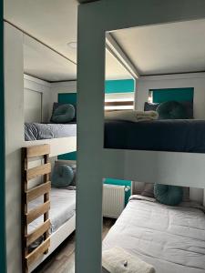 a bedroom with two bunk beds and a mirror at Casa Entre Glaciares in Puerto Natales