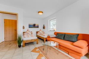 Bauer Haug في ديتمانسريد: غرفة معيشة مع أريكة برتقالية وطاولة