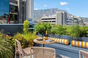 a table and chairs on a balcony with a view of mountains at Hotel Apt, Wifi, Roof Deck, Central CBD, 247 Power in Cape Town