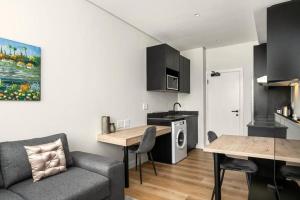 a kitchen and living room with a couch and a table at Hotel Apt, Wifi, Roof Deck, Central CBD, 247 Power in Cape Town