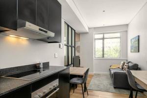 a kitchen and living room with a table and a couch at Hotel Apt, Wifi, Roof Deck, Central CBD, 247 Power in Cape Town