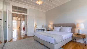 Un dormitorio blanco con una cama grande y un pasillo en Sunny Belém Home by LovelyStay en Lisboa