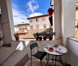 una mesa pequeña y sillas en un balcón con vistas en Casa Florian, en Lucca