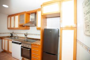 帕特納的住宿－Precioso Apartamento en Valencia，厨房配有木制橱柜和黑色冰箱。