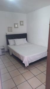 a bedroom with a large bed with white sheets at Amoblado centro de la Moda in Itagüí