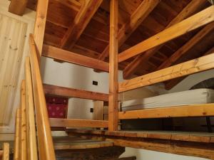 a loft bed in a room with wooden ceilings at La mine d'Antan in Ollomont