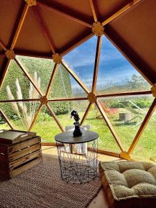 une chambre avec une grande fenêtre dans une tente dans l'établissement Dôme/insolite/parc régional du Pilat, à Saint-Appolinard