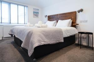 a bedroom with a large bed with a wooden headboard at The Nook - Self Serviced Accommodation in St Ives