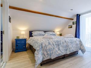 a bedroom with a bed with a blue and white bedspread at 2 bed in Week St Mary 82455 in Week Saint Mary