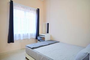 Postel nebo postele na pokoji v ubytování Peach Homestay Tasik Puteri