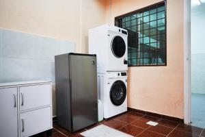 una lavadora y secadora junto a una pared en Peach Homestay Tasik Puteri, en Rawang