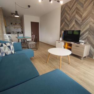 sala de estar con sofá azul y mesa en Sozopol Homes Z&Z apartments en Sozopol