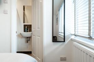 a bedroom with a sink and a mirror on the wall at The Nook - Self Serviced Accommodation in St Ives