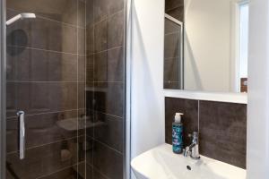 a bathroom with a shower and a sink and a mirror at The Nook - Self Serviced Accommodation in St Ives
