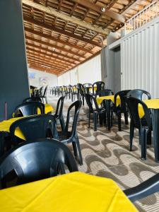 a row of tables and chairs with yellow tables at Hotel Nossa Senhora de Lourdes in Trindade