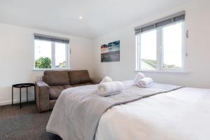 a white bedroom with a bed and a couch at The Nook - Self Serviced Accommodation in St Ives