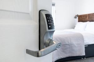 a remote control hanging on a wall next to a bed at The Nook - Self Serviced Accommodation in St Ives