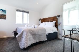 a bedroom with a bed and two windows at The Nook - Self Serviced Accommodation in St Ives
