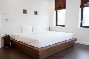 ein weißes Schlafzimmer mit einem großen Bett mit weißer Bettwäsche in der Unterkunft Valentina Castle - Melorita Hòa Lạc in Hanoi