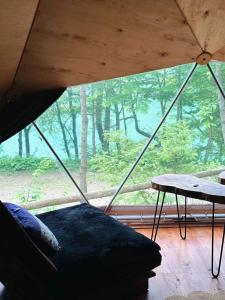 a bed and a table in a room with a large window at Ala Glamping in Mudurnu