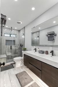 La salle de bains est pourvue d'un lavabo, de toilettes et d'une douche. dans l'établissement Miami Oasis, Spacious 4-Bedroom Home with Pool, à Miami