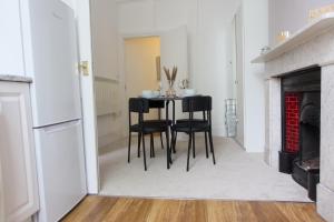 uma sala de jantar com uma mesa e cadeiras pretas em 1 bedroom apartment - The Opal em Cheltenham