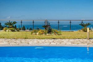 a blue swimming pool with a view of the ocean at Villas Goudis in Tsoukalades