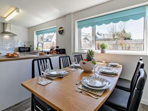 a dining room with a table and chairs and a kitchen at 3 Bed in Crackington Haven 09117 in Saint Gennys