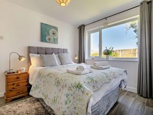 a bedroom with a bed and a large window at 3 Bed in Crackington Haven 09117 in Saint Gennys