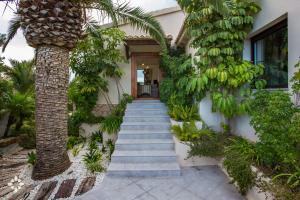 eine Treppe, die zu einem Haus mit einer Palme führt in der Unterkunft Villa Barbados by Abahana Luxe in Fanadix