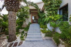 a staircase leading to a house with a palm tree at Villa Barbados by Abahana Luxe in Benissa