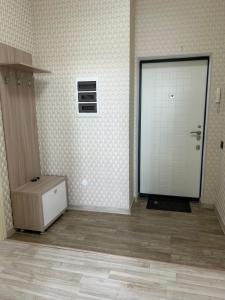 Una puerta blanca en una habitación con suelo en Двухкомнатная квартира на набережной, en Astana