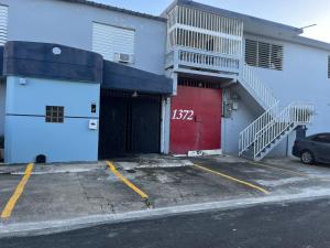 - un bâtiment blanc avec une porte rouge et des escaliers dans l'établissement Metropolitan Apartment, à San Juan
