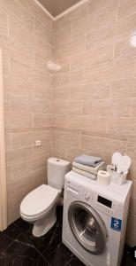 uma casa de banho com um WC e uma máquina de lavar roupa em Двухкомнатная квартира на набережной em Astana