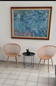 Eine Katze, die auf einem Tisch neben zwei Stühlen sitzt. in der Unterkunft Group Unit Great Location in San Juan