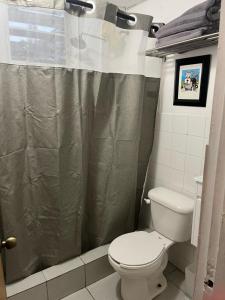 a bathroom with a toilet and a shower curtain at Group Unit Great Location in San Juan