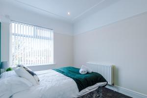 a white bedroom with a bed and a window at Cosy Modern 3-BR Apartment - Sleeps 5 in Liverpool