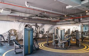 a gym with cardio equipment and a wall with graffiti at Hububb Luxury Studio One Marina in Dubai