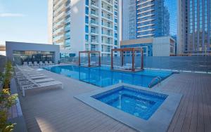 a swimming pool on top of a building with tall buildings at Hububb Luxury Studio One Marina in Dubai