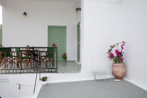 a porch with a table and chairs and a vase of flowers at Melitini's House in Alinda