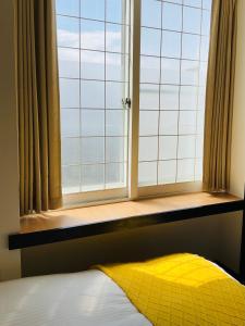 a bedroom with a window with a yellow blanket on a bed at Warm House3 in Sapporo