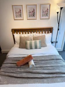 a bed with a wooden headboard and a towel on it at Luxury Rooms just off broad St Walking distance to city centre in Birmingham