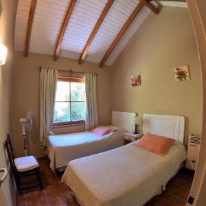 - une chambre avec 2 lits et une fenêtre dans l'établissement Las Cumbres Apart & Suites, à San Martín de los Andes