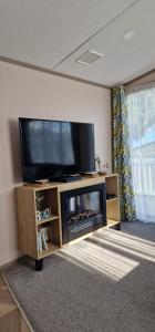 a living room with a flat screen tv on a entertainment center at Holibobs in Paignton