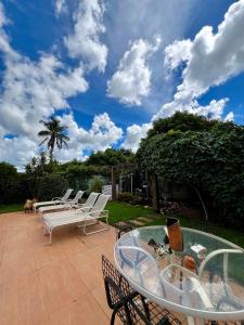 a group of chairs and a glass table on a patio at A Cozy Little House in a Beautiful Property in Brasilia +11 photos