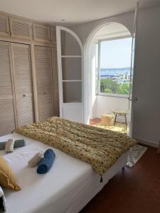 un grande letto in una camera da letto con una grande finestra di Maison de village rénovée avec vue mer exceptionnelle a Sainte-Maxime