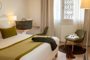 a bedroom with a bed and a chair and a window at The Passage - Urban & Lifestyle Hotel in Basel +50 photos
