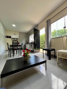 a living room with a table and a kitchen at A Cozy Little House in a Beautiful Property in Brasilia