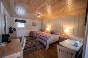 a bedroom with a bed and a desk and a table at The Snowshoe Lodge in Lake Placid